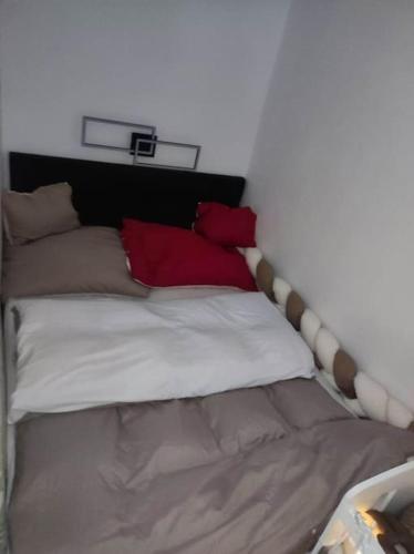a bed with red and white pillows on it at Štýlový apartmán in Dubnica nad Váhom