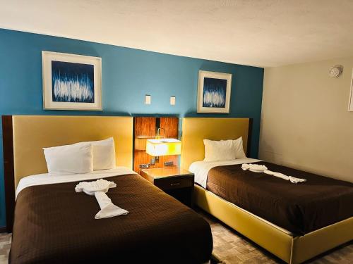 a hotel room with two beds with towels on them at The Boston Inn in Westminster
