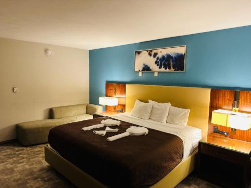 a hotel room with a large bed and a chair at The Boston Inn in Westminster