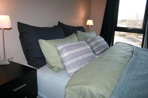 un letto con cuscini sopra in una camera da letto di Ny leilighet med fantastisk sjøutsikt i Fredrikstad a Kråkerøy