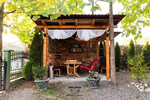 a pergola with a table and chairs in a yard at Heaven Heart - Apartmani Tuzla in Tuzla