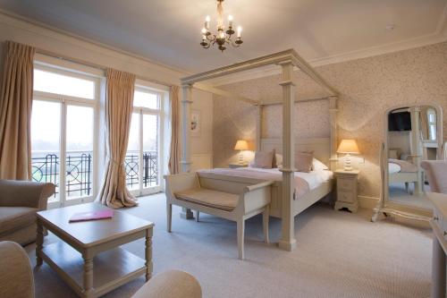 a bedroom with a canopy bed and a living room at The Bell Hotel in Sandwich