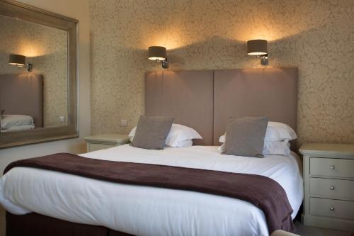 a bedroom with a large bed with a large mirror at The Bell Hotel in Sandwich