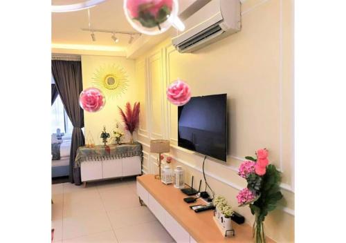 a living room with a television and pink flowers at 北欧ING风格豪华日出海景套房 Nordic ING Luxury Seaview Suite in Tanjong Tokong
