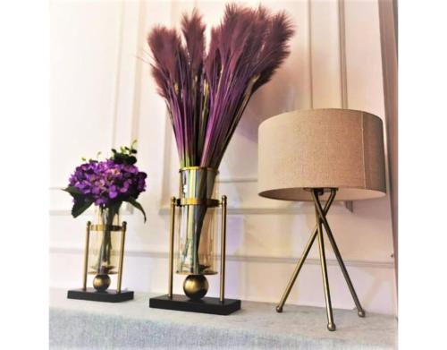 two vases with purple flowers and a lamp on a shelf at 北欧ING风格豪华日出海景套房 Nordic ING Luxury Seaview Suite in Tanjong Tokong