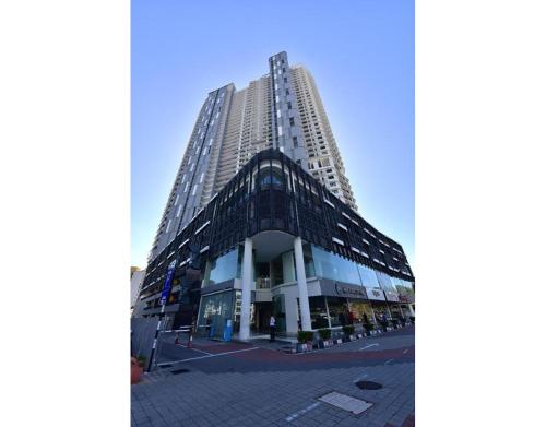 a tall building in front of a street at 北欧ING风格豪华日出海景套房 Nordic ING Luxury Seaview Suite in Tanjong Tokong