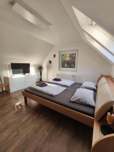 a large bedroom with a large bed in a attic at Riverside Guesthouse in Ig