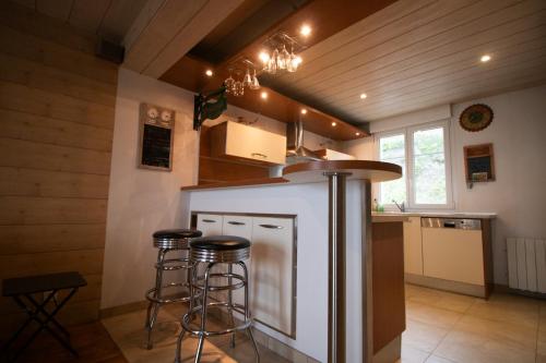 une cuisine avec un comptoir et des tabourets dans une pièce dans l'établissement les pieds dans l'eau, à Granville
