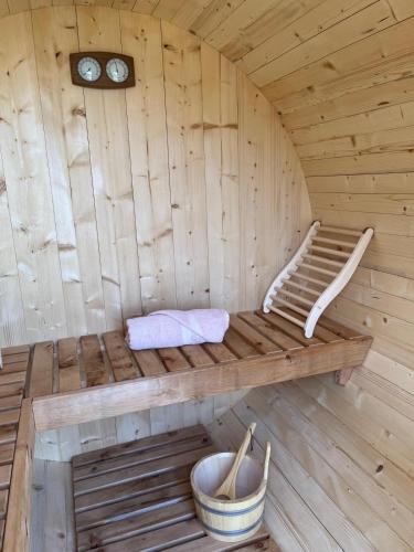 a wooden sauna with a bench and a clock at Il Bosco Incantato in Borgo San Dalmazzo