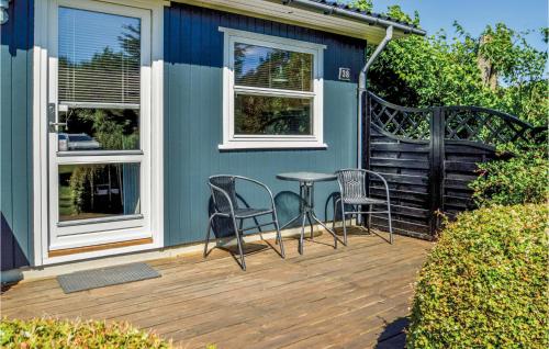 a deck with chairs and a table on a house at Holiday Home Fjordparken Farsø Vi in Hvalpsund