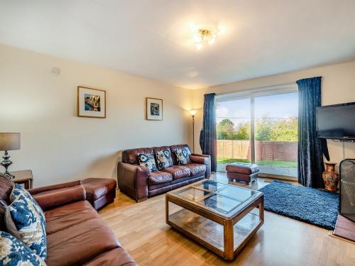 a living room with leather couches and a tv at Heritage Wharf in Mow Cop