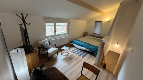 a small bedroom with a bed and a chair at Le Chaufour Lille in Lille