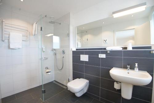 a bathroom with a sink and a toilet and a shower at Hotel Go2Bed Weil am Rhein - Basel in Weil am Rhein