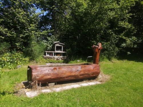 a wooden object sitting in the grass in a field at Chalet près de Gérardmer zone Natura 2000 in Le Tholy