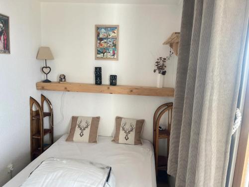 une chambre avec un lit avec deux oreillers dessus dans l'établissement Appartement charmant - Chamrousse - 36 m² - Vue montagne, à Chamrousse
