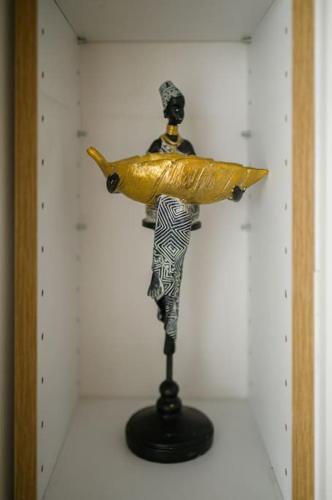 una statua di una donna che tiene in mano un oggetto d'oro su un muro di 4U Apartment a Skopje