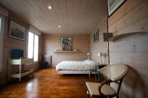 une chambre avec un lit, un bureau et une chaise dans l'établissement les pieds dans l'eau, à Granville