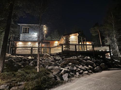 a log cabin at night with a pile of rocks at Ankkalinna in Pyhätunturi