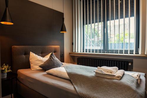 a bedroom with a bed with pillows and a window at Liro Hotel Moers in Moers