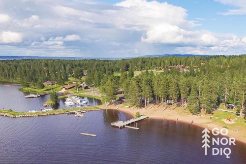 an aerial view of a lake with a dock and a beach at The Black Deer Lodge in Tällberg