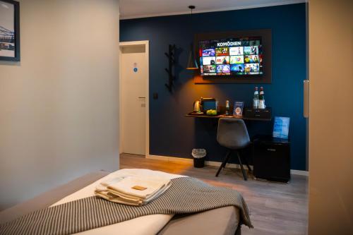 a room with a bed and a table with a television at Liro Hotel Moers in Moers