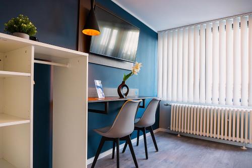 a dining room with blue walls and a table and chairs at Liro Hotel Moers in Moers