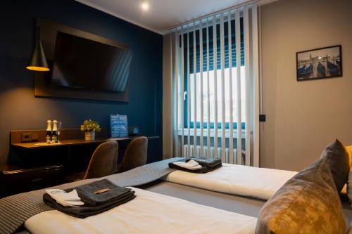 a hotel room with two beds and a flat screen tv at Liro Hotel Moers in Moers