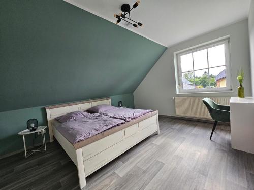a bedroom with a bed and a table and a window at Stilvoll eingerichtetes Ferienhaus in ruhiger Lage in Bremerhaven