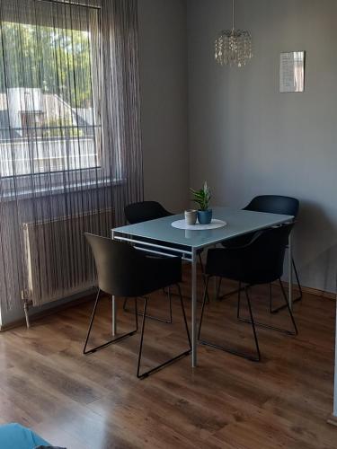 a dining table and chairs in a living room at Lia Apartman in Nyíregyháza