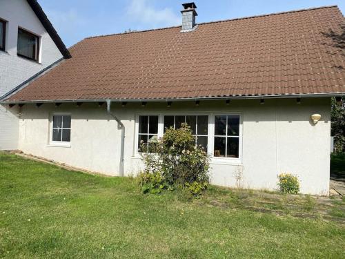 a white house with a brown roof at Rollstuhlgerechter Ferienbungalow in ruhiger Lage in Bad Harzburg
