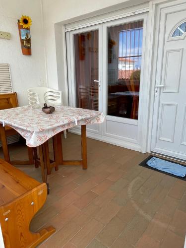 a dining room with a table and a glass door at charme et simplicité de ce nouveau bien in Empuriabrava