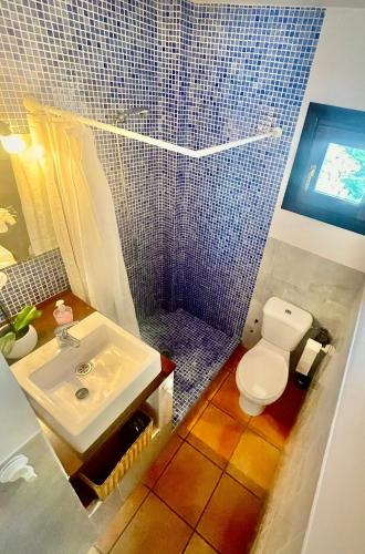 a bathroom with a sink and a toilet and a shower at Alojamiento Fuente Alta in Cazorla