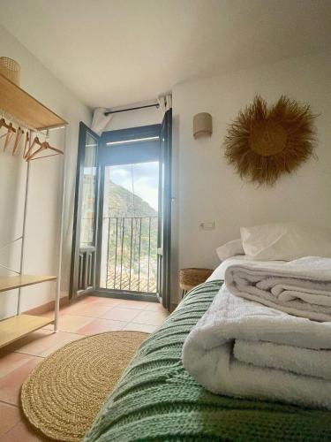 a bedroom with a bed with a view of a balcony at Alojamiento Fuente Alta in Cazorla