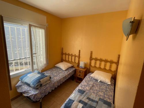 a bedroom with two beds and a window at charme et simplicité de ce nouveau bien in Empuriabrava