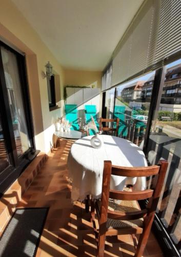 une salle à manger avec une table et des chaises sur un balcon dans l'établissement Appartement cosy proche mer, à Villers-sur-Mer
