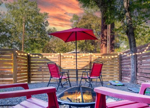 a fire pit with chairs and a red umbrella at Modern 2-Story Cowboy Pool Gem with King Beds in East DT Walk to lake, La BBQ in Austin