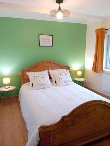 a bedroom with a large wooden bed with two tables at Gîte La Petite Roche in Arthon