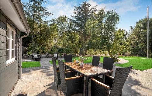 a wooden table and chairs on a patio at 4 Bedroom Amazing Home In Hurup Thy in Sønder Ydby