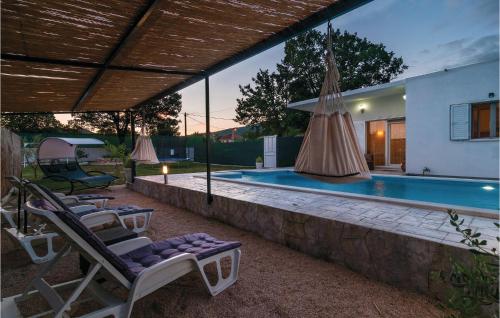 a swimming pool with two lounge chairs next to a house at Two-Bedroom Holiday Home In Neoric in Neorić