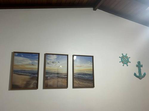 four pictures of the beach on a wall at Casa toda Equipada 900 metros da Lagoa, próxima as praias in São Pedro da Aldeia