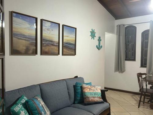 a living room with a couch and four pictures on the wall at Casa toda Equipada 900 metros da Lagoa, próxima as praias in São Pedro da Aldeia