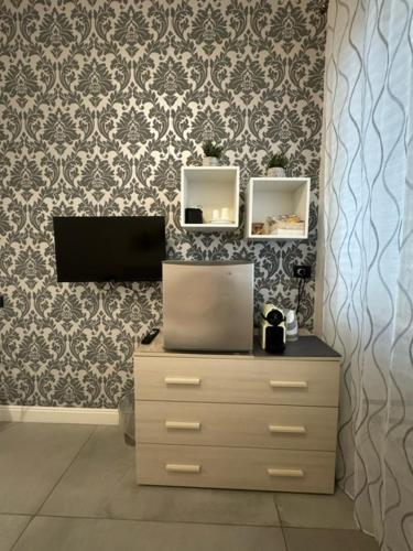 a dresser with two mirrors and a wall with a wallpaper at Flaminio Holidays in Rome
