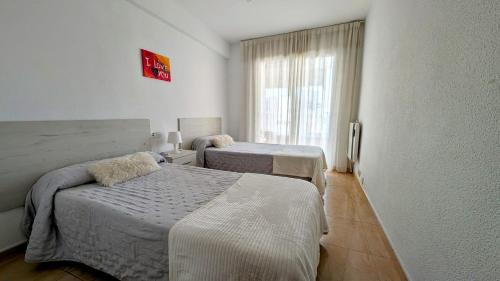una habitación con dos camas y una ventana en Brisas de Levante, en Benidorm