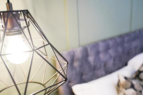 a glass lamp sitting on top of a couch at Studio 44 - Spacious Studios - City Centre Location - Contractor Friendly - Free WiFi - Smart TV - Desk Space - Well Designed - Communal Garden in Peterborough