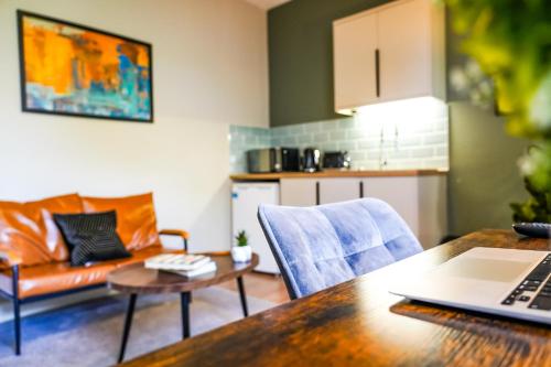 a kitchen and a living room with a table at Studio 44 - Spacious Studios - City Centre Location - Contractor Friendly - Free WiFi - Smart TV - Desk Space - Well Designed - Communal Garden in Peterborough