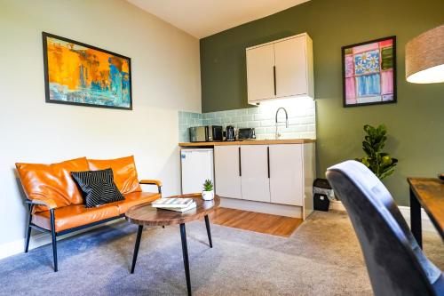 a living room with a couch and a table at Studio 44 - Spacious Studios - City Centre Location - Contractor Friendly - Free WiFi - Smart TV - Desk Space - Well Designed - Communal Garden in Peterborough