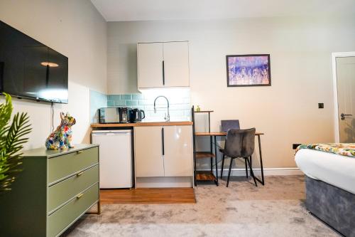 a kitchen and living room with a table and a couch at Studio 44 - Spacious Studios - City Centre Location - Contractor Friendly - Free WiFi - Smart TV - Desk Space - Well Designed - Communal Garden in Peterborough