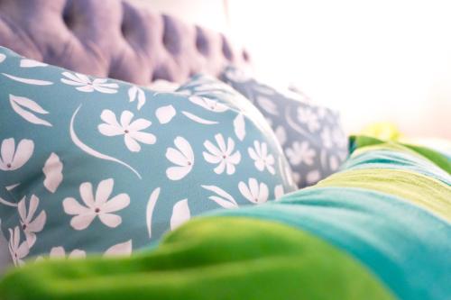 a couch with a pillow with flowers on it at Studio 44 - Spacious Studios - City Centre Location - Contractor Friendly - Free WiFi - Smart TV - Desk Space - Well Designed - Communal Garden in Peterborough