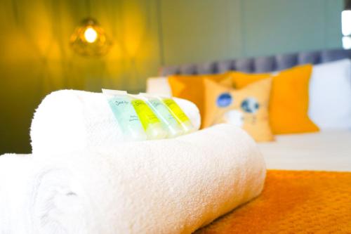 a roll of paper towels sitting on a bed at Studio 44 - Spacious Studios - City Centre Location - Contractor Friendly - Free WiFi - Smart TV - Desk Space - Well Designed - Communal Garden in Peterborough