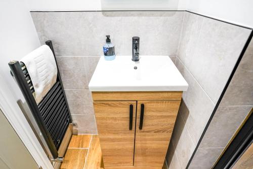 a small bathroom with a sink and a chair at Studio 44 - Spacious Studios - City Centre Location - Contractor Friendly - Free WiFi - Smart TV - Desk Space - Well Designed - Communal Garden in Peterborough